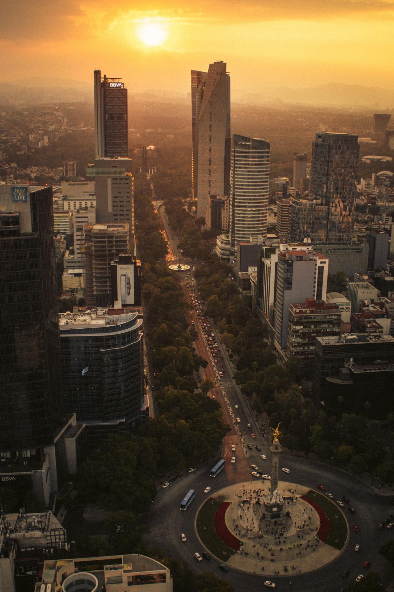 A stunning aerial view of Mexico City's skyline and Angel of Independence at sunset.